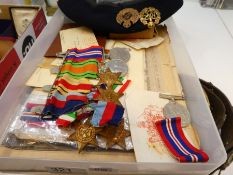 A WW2 medal group including the Africa Star, other similar medals and paperwork and a WW2 era beret,