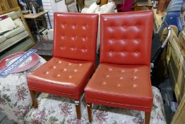 A pair of retro leatherette and buttoned low chairs