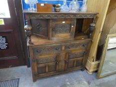 A reproduction oak court cupboard having carved decoration