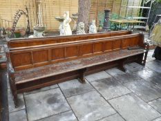 A pair of old Church pews having panelled backs, 316cm