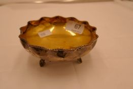 A Chinese silver dish with gilt bowl interior and scallop design rim. On three feet, stamped 25.5 oz