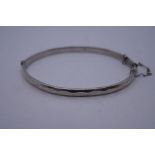 Georg Jensen; A silver bangle by Georg Jensen, marked G J LTD, Hallmarked, 7cm diameter with safety