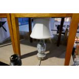 A soap stone table lamp decorated flowers and a wrought iron adjustable standard lamp