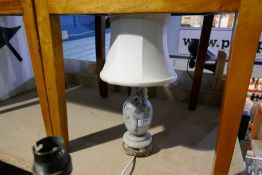 A soap stone table lamp decorated flowers and a wrought iron adjustable standard lamp