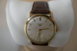 A 9ct gold Longines gents watch dated from 1965. Winds and ticks showing a cream dial and smaller se