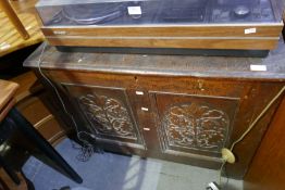 An antique oak coffer having carved panel and front