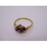 Pretty 9ct gold cross over design dress ring with central panel, inset with rubies and diamonds, siz