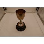 A silver trophy cup with beaded pedestal foot and central engraved message on the front.17cm high ap