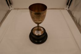 A silver trophy cup with beaded pedestal foot and central engraved message on the front.17cm high ap