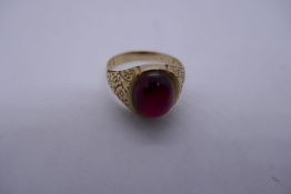 Yellow gold gents signet ring inset with large red stone, possibly ruby, cabouchon cut mounted in fl