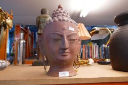 A cast metal head depicting the Deity Buddha