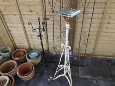 A wrought iron gate and two similar stands