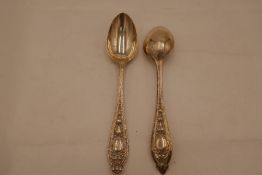 A pair of Victorian silver decorated dessert spoons with ornate handles and repoussed design with de