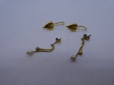 Two pair of yellow metal earrings, one in the form of leaves