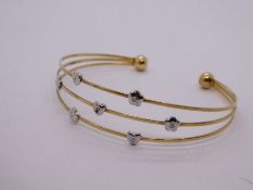9ct yellow gold open bangle with three sections applied flowerhead detail, marked 375, 5.2g approx