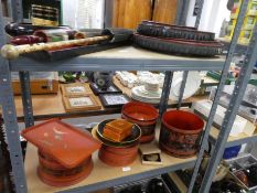 Two shelves of oriental lacquer items, parasols, etc