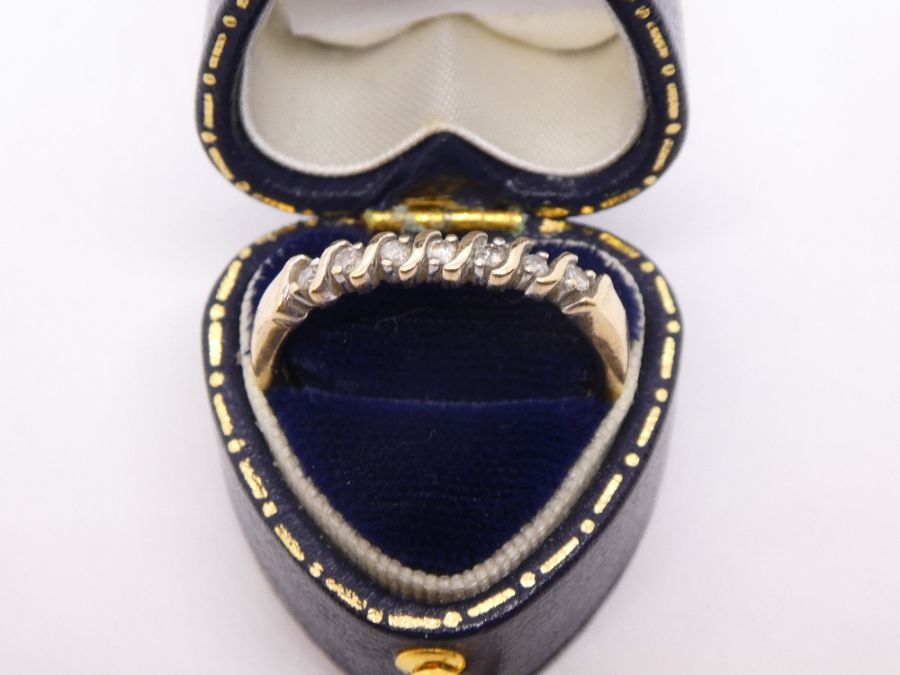 9ct yellow gold ring set with 7 diamonds, size S, approx 3g, in tooled leather heart shaped box. mar
