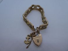 Antique 9ct gold gate articulated bracelet with quatrefoil motifs and heart shaped padlock, by Charl