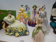A quantity of Royal Doulton figurines including 'Easter Day', 'Paisley Shawl' and 'Autumn Breezes',