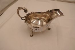 A heavy silver gravy boat on three feet. Scallop edge rim, hallmarked Sheffield 1931. Thomas Bradbur