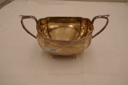 A two handled sugar bowl on four ball feet, hallmarked Chester 1930, J Blanckensee and Son Ltd. 5.01