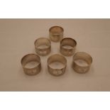 A quantity of six silver napkin rings marked 1-6 with engine turned design. Hallmarked London 1973,