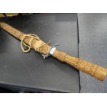 An Eastern sword having carved wooden handle and scabbard