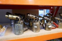 A selection of vintage blow torches, mostly brass