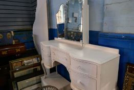 A white painted dressing table having 5 drawers and a similar headboard and pair of 3 drawer chests
