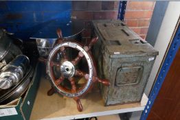 A small ships wheel, an ammunition case and a coal bin