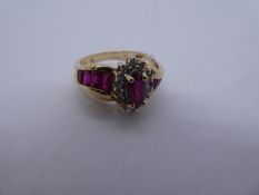 10K yellow gold ring with marquise cut ruby surrounded clear stones, the shoulders set with baguette