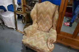 A wing armchair on cabriole legs