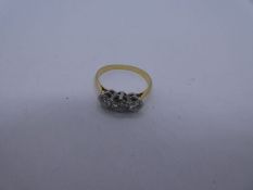 Unmarked yellow metal diamond trilogy ring. The central stone 0.20 carat approx, size K