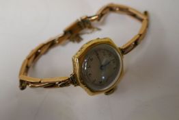 18ct gold vintage watch with a plated gold bracelet. Winds and ticks