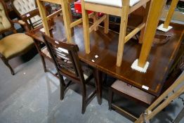 An antique mahogany two flap dining table having inlaid decoration and a set of five chairs having f