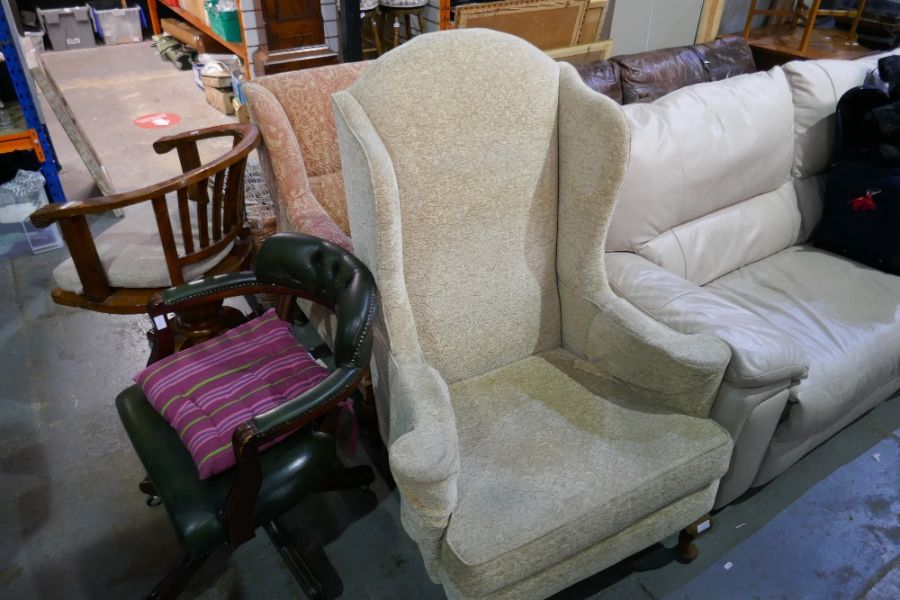 An antique armchair having carved legs and a later wing armchair