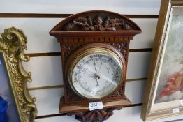 An early 20th century carved walnut aneroid barometer