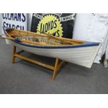 A wooden rowing boat on stand complete with oars and thick glass top (used as coffee table) 155cm