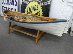 A wooden rowing boat on stand complete with oars and thick glass top (used as coffee table) 155cm