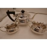 A silver three piece tea service comprising a teapot, two handled sugar bowl and milk jug. Hallmarke