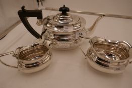 A silver three piece tea service comprising a teapot, two handled sugar bowl and milk jug. Hallmarke