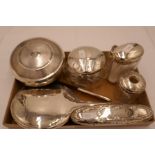 A quantity of silver dressing table items to include a silver backed mirror, cut glass jar, a comb w