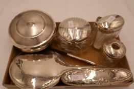 A quantity of silver dressing table items to include a silver backed mirror, cut glass jar, a comb w