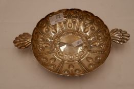 A large, heavy Edwardian silver porringer with repoussed decorative design of fruit, beading etc. F