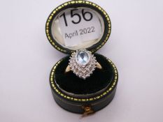 Contemporary 9ct gold aquamarine and diamond cluster ring in a marquise shaped mount, central oval a
