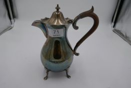 A silver coffee pot on four feet. Decorative top, hallmarked Sheffield 1912, Harrison Fisher & Co. a