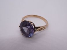 Unmarked yellow metal dress ring, set with large purple stone, possibly Sapphire, with floral engrav