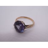 Unmarked yellow metal dress ring, set with large purple stone, possibly Sapphire, with floral engrav