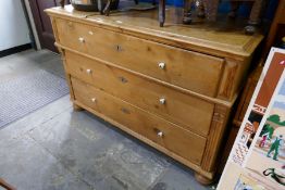 An old French pine chest having three long drawers on bun feet
