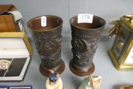 A pair of early 20th century bronze vases decorated flowers and leaves with circular plaques, 14.5cm